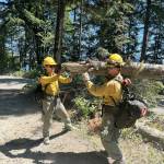 Fire crews move fuel and debris along the Forest Service Road 24 while combating the Bear Gulch Fire along Lake Cushman.