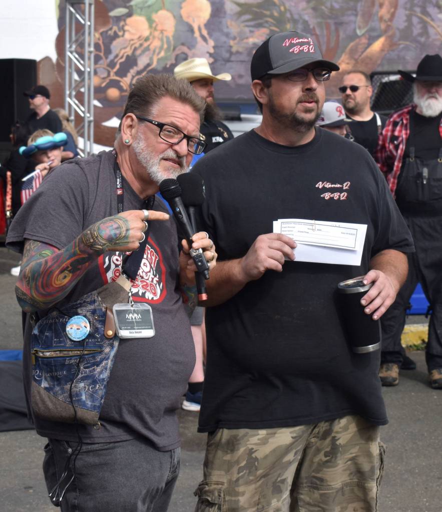 Media personality Rick Moyer hands the grand prize in the BBQ tasting competition to Vitamin Q.
