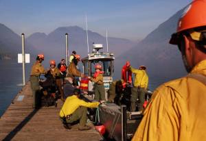 Erika Schultz / The Seattle Times
The Zigzag Interagency Hotshot Crew gets ready to cross Lake Cushman on Thursday to work on the Bear Gulch fire. This day, the wildland firefighters were improving space around homes on the northwest side of the lake.