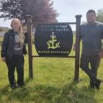 Barbara Weza photos / Chaplains of the Harbor
Chaplains on the Harbor staff pose with Harbor Roots Farm sign, which reads: Healing the land and people together.