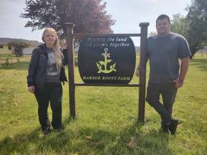 Barbara Weza photos / Chaplains of the Harbor
Chaplains on the Harbor staff pose with Harbor Roots Farm sign, which reads: Healing the land and people together.