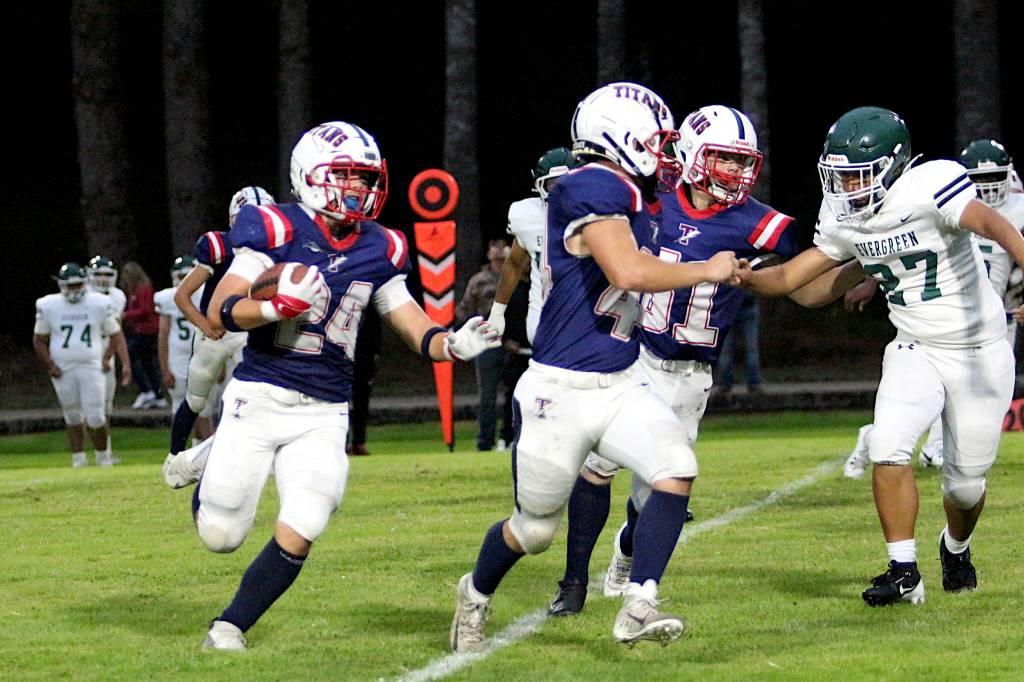 RYAN SPARKS | THE DAILY WORLD Pe Ell-Willapa Valleys Lucas Lusk (24) followed the blocks of Spud Swogger (middle) and Hank Swartz (right) during the Titans 41-8 win over Evergreen (Seattle) on Friday at Crogstad Field in Menlo.