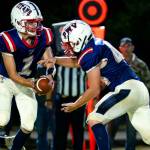 PHOTO BY MATT RUMBLES Pe Ell-Willapa Valley quarterback Brody Ritzman (left) hands the ball off to running back Spud Swogger during a win over Evergreen (Seattle) last week. The Titans host Blaine on Friday in Pe Ell.