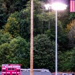 A logger scrambles to the top of a tall pole.