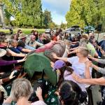 Emily Fitzgerald / Washington State Standard
A crowd of about 120 people bless a totem pole and 10 cedar masks carved by the Lummi Nations House of Tears outside of the Capitol building in Olympia on Sept. 8, as part of the Indigenous-led campaign Xaalh and the Way of the Masks. The totem and masks will travel 1,700 miles between rally sites in Washington and Oregon before being given to the Lower Elwha Klallam Tribe west of Port Angeles on Sept. 20.