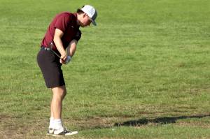 PHOTO BY HAILEY BLANCAS Montesanos Colton Grubb chips from the fairway during a Bulldogs win over Rochester on Wednesday at the Riverside Golf Course in Chehalis.
