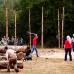 A woman participates in the axe throw.