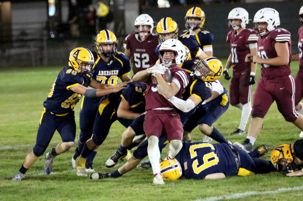 RYAN SPARKS | THE DAILY WORLD Hoquiam running back Kingston Case (5) is wrapped up by Aberdeen defensive back Luke Martin (12) during the Bobcats 43-7 win in the 120th Myrtle Street Rivalry on Friday at Olympic Stadium in Hoquiam.