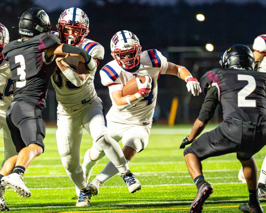 PHOTO BY MATT RUMBLES 
Pe Ell-Willapa Valleys Lucas Lusk (middle) looks for running room against Raymond-South Bend on Oct. 3. The Titans take on Ilwaco at 7 p.m. on Friday in Menlo.