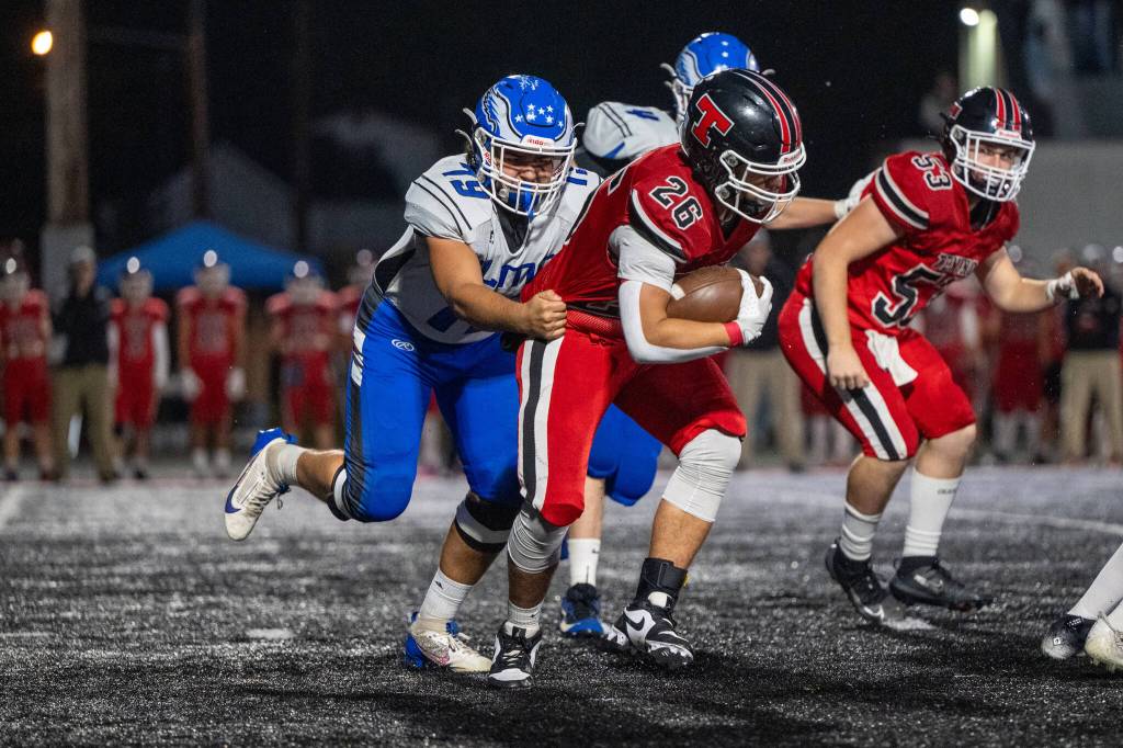 PHOTO BY FOREST WORGUM Elma lineman Marcus Jones (79) grabs a hold of Tenino running back Miguel Espinoza during the Eagles 42-0 loss on Friday in Tenino.