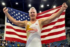 SUBMITTED PHOTO Former Elma wrestler Kevin Pine holds an American flag after winning a gold medal at the Veteran World Wrestling Championships on Friday in Hungary.
