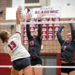PHOTO BY FOREST WORGUM 
Houqiams Piper Stankavich (left) spikes the ball while defended by Montesanos Carmen Bennefeld and Grace Gooding (7) during the Bulldogs straight-set win on Thursday in Montesano.