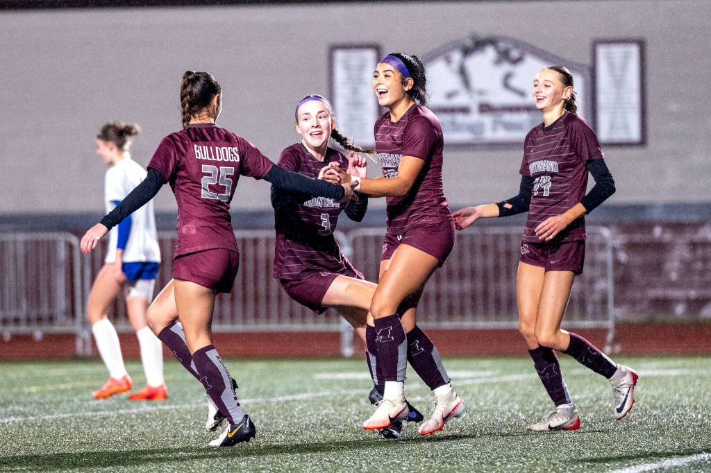 PHOTO BY FOREST WORGUM Montesanos Lizzy Kolar (25), Ashley Hill (3), Jaelyn Butterfield and Haley Schweppe (44) celebrate a goal during the Bulldogs 8-0 win over Rochester in a 1A District 4 Tournament semifinal game on Thursday at Montesano High School.
