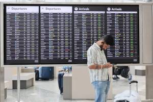 Kevin Clark / The Seattle Times
A traveler at the international ticker board Friday morning at Seattle-Tacoma International Airport in SeaTac on November 7. The FAA has reduced flights by 10% out of the nations 40 busiest airports, including SEA.