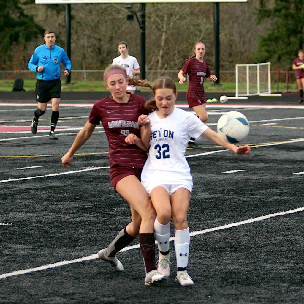 RYAN SPARKS | THE DAILY WORLD Montesano midfielder Lainey Robinson (left) boots the ball away from Seton Catholics Conley Richardson during the Bulldogs 3-2 loss (5-4 on penalty kicks) in the 1A District 4 Championship on Saturday in Tenino.