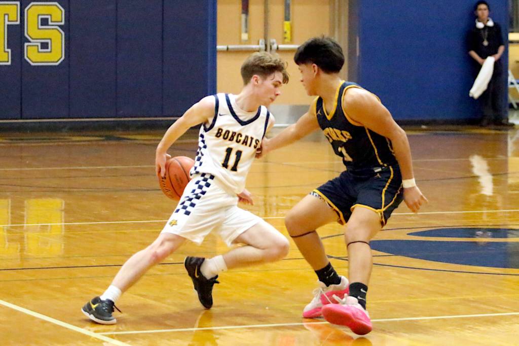 RYAN SPARKS | THE DAILY WORLD Aberdeen guard Justin Howard (11) dribbles behind the back against Forks Estevan Ramos during a 62-34 victory on Wednesday in Aberdeen.