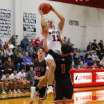 PHOTO BY LARRY BALE Raymond-South Bends Chris Banker (12) goes up for a shot while defended by Ocostas Bryce Bottleson (1) and Brayden Dungey during a game on Wednesday at Raymond High School. Ocosta won in overtime 73-68.
