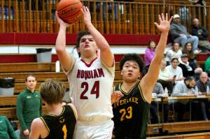 RYAN SPARKS | THE DAILY WORLD Hoquiams Lincoln Niemi (24) shoots while defended by Overlakes Carter Douvia (1) and Derek Li during the Grizzlies 55-54 victory on Tuesday at Hoquiam Square Garden.