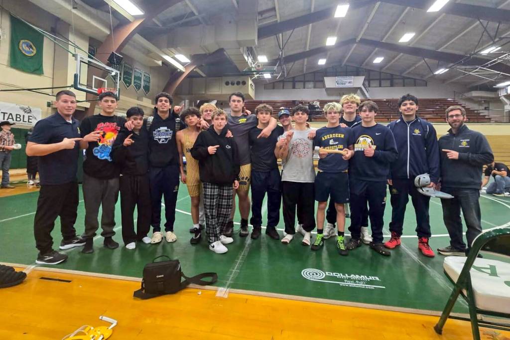 ERICA MCCRORY | MCCRORY PHOTOGRAPHY Aberdeen head coach Jeff Hatton (far left) and his team celebrate a victory at the Battle for the Axe dual-meet tournament on Saturday in Port Angeles. Aberdeen was led by Adonis Hammonds (fourth from left) and Ryder Lessard (holding axe) who each went 4-0 at the meet.