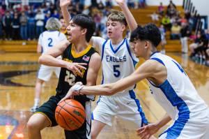 PHOTO BY MIKE ROBERTS Elmas Trey Yeager (5) and Trayton Webb defend against North Beachs Dakota Bryson during the Eagles 66-24 victory on Monday at Elma High School.