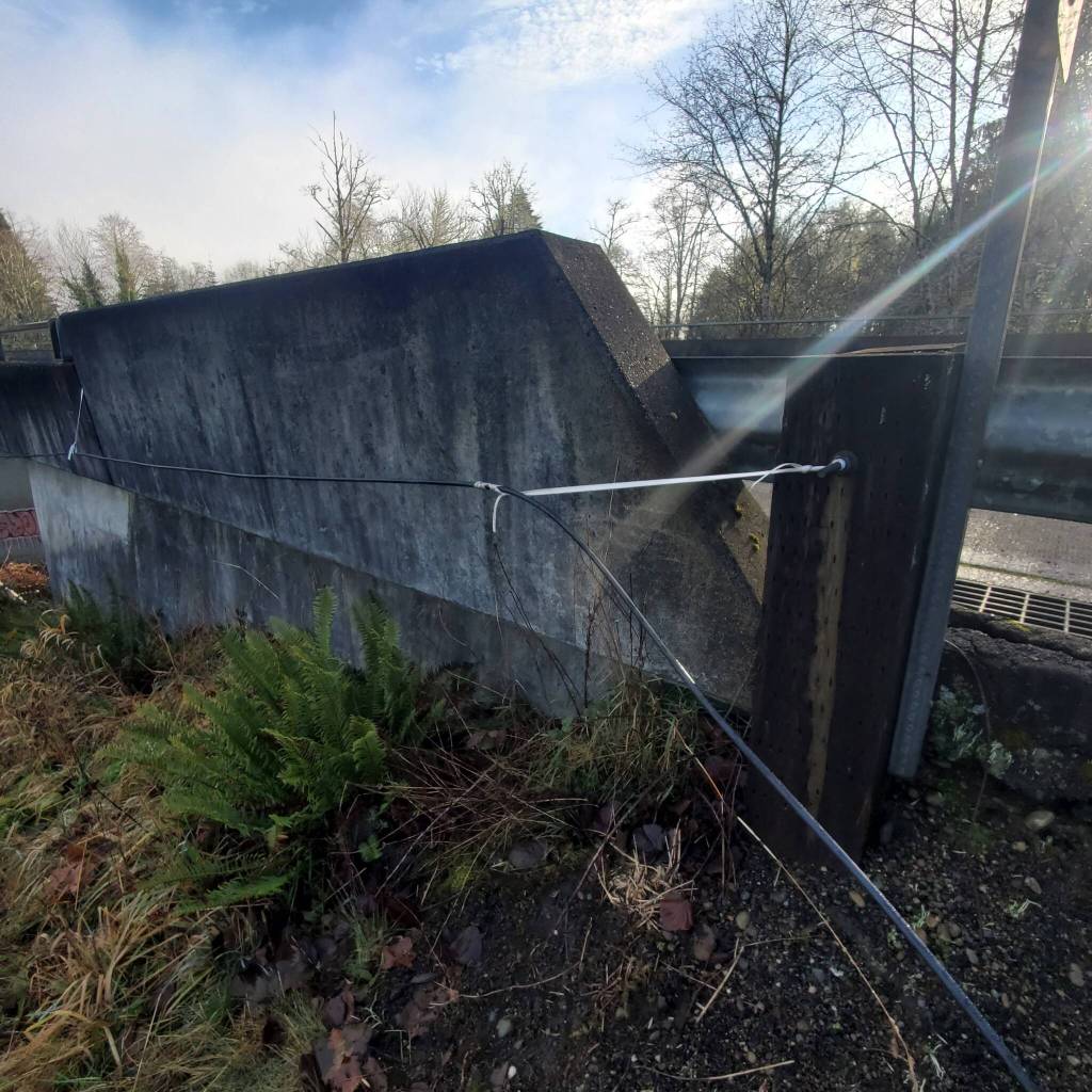 Andrea Watts / The Daily World
When the CenturyLink crew arrived to restring the phone and internet cable, a crew member said the procedure was unsafe, and the procedure was stopped. They left, leaving behind the cable attached the length of Gleason Bridge, and the ends of the cable are lying on the ground.