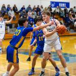 PHOTO BY MIKE ROBERTS Elma post Dylan Myer (right) is defended by Rochesters Owen Driver (20) and Tyson Canales (21) during the Eagles 68-37 victory on Friday in Elma.