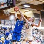 PHOTO BY MIKE ROBERTS Elmas Isaac McGaffey (3) rises up for a slam dunk against Montesanos Mason Fry during the Eagles 54-32 defeat on Friday in Montesano.