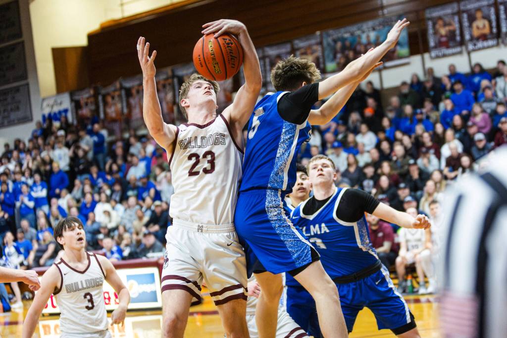 PHOTO BY MIKE ROBERTS Montesanos Caden Grubb (23) snags a rebound against Elmas Trey Yeager during the Bulldogs 54-32 victory on Friday in Montesano.