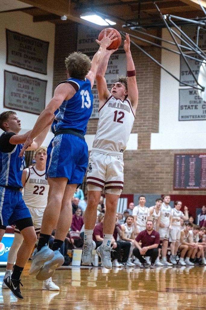 PHOTO BY FOREST WORGUM Montesanos Ryan Weidman (12) hits a jump shot while defended by Elmas Dylan Myer during the Bulldogs 54-32 victory on Friday at Montesano High School.