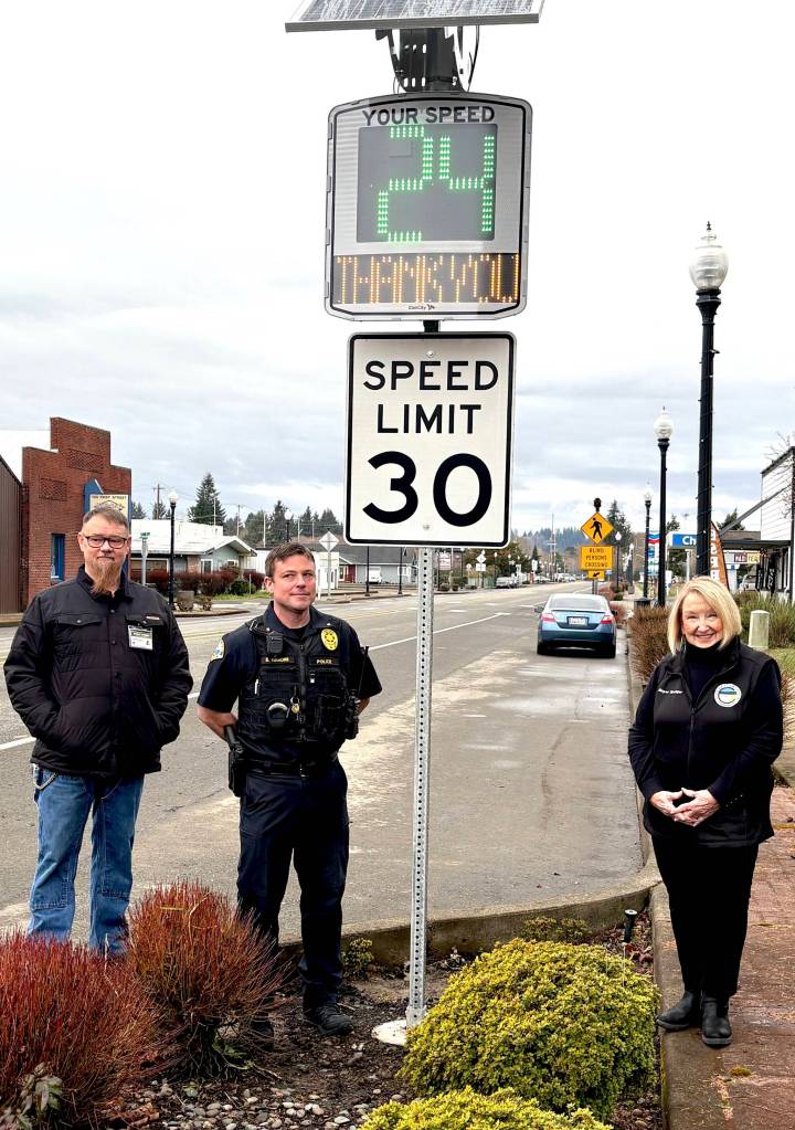 Jerry Knaak / The Daily World
City of Cosmopolis Public Works Lead Donnie Fowler, Aberdeen Police Department Commander Steve Timmons and Cosmopolis Mayor Linda Springer pose for a photo with one of two new radar speed signs recently installed on First Street.