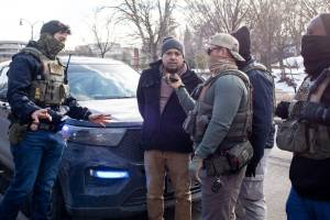 Nicole Neri / Minnesota Reformer
ICE agents allow a driver to talk to his wife as they arrest him and his passenger during a traffic stop on Feb. 11, in Minnesota.