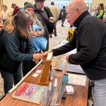 Jerry Knaak / The Daily World
John Shaw helps a festivalgoer at the Beachcombers and Glass Float Expo.