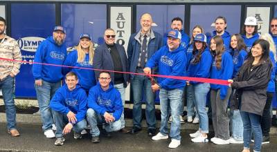 The Daily World photos
Marty Clark, owner of Olympia Auto Sales and RV, joined by Aberdeen Mayor Doug Orr (center), Larry Burgher from Greater Grays Harbor, Inc. (to Orrs right) 
and the rest of the Olympia Auto Sales and RV team prepares to cut the ribbon at their grand opening Saturday.