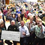 Deputy Sheriff’s Association of Grays Harbor president Jeremy Holmes poses for a photo with the ceremonial check with the assembled 100+ Women Who Care cheering him on.