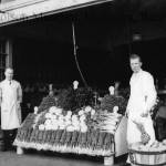 Mark Swanson / The Polson Museum
Pictured is a vegetable stand at Swansons market. Green onions, cauliflower and celery are most recognizable. A wooden basket full of potatoes (at right) is topped off with a pineapple. Note the sign above the basket advertising some canned goods Extra Special 2 Cans 15¢. It appears to be an earlier market in Hoquiam. The date of this photograph is not known, but the general appearance and the 15¢ special argue for circa 1920. These men appear to be members of the Swanson family, father and son.