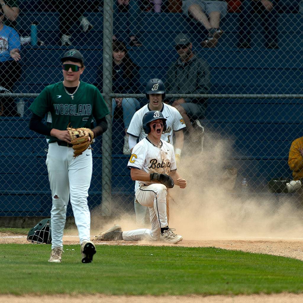 ELENA MILLS PHOTOGRAPHY Aberdeens Aidan Baker (kneeling) reacts after scoring a run during a 5-1 win over Woodland in a 2A District 4 play-in game on Friday at Pioneer Park in Aberdeen.