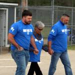 RYAN SPARKS | THE DAILY WORLD Mitchell Todds relatives (from left) Dalton Todd (son), Marlowe Todd (mother) and Jerry Todd (brother) walk to the pitching circle during a ceremony honoring the former Elma softball coach who dies in a vehicle accident on May 3.
