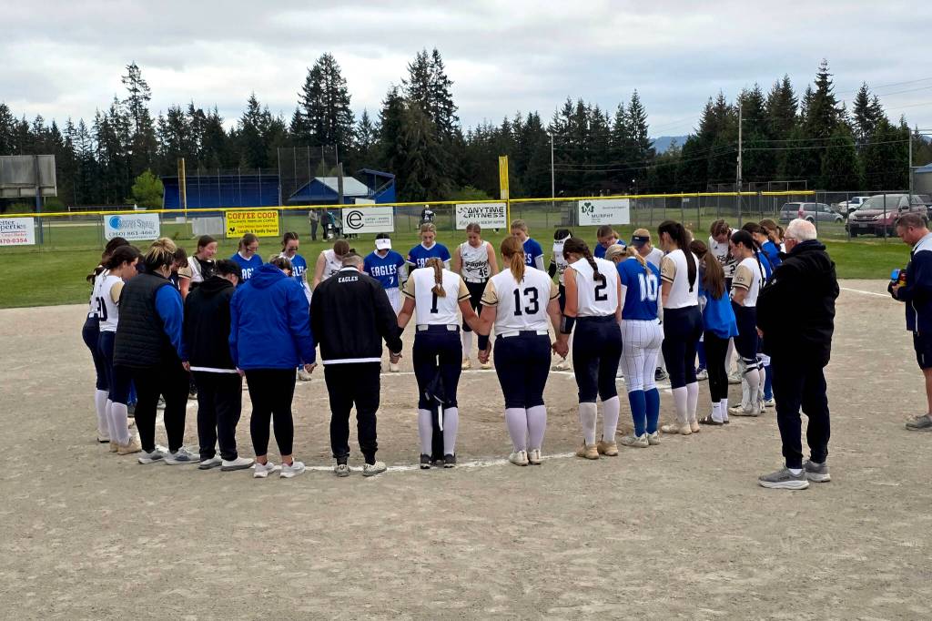 RYAN SPARKS | THE DAILY WORLD Players from Elma (blue) and Cedar Park Christian say a prayer for Mitchell Todd and his family after a game on Friday in Elma.