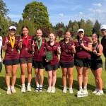 SUBMITTED PHOTO The Montesano Bulldogs (from left) assistant coach Loyal Linton, Makenzie Hart, Makena Blancas, Ashley Hill, Rossi Newbill, Rory Gourdin, Lucy Scott, assistant coach Hailey Blancas and assistant coach Doug Galloway pose for a photo after winning the 1A District 4 team championship on Tuesday at the Tumwater Valley Golf Course.