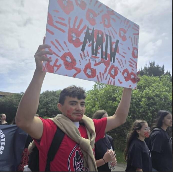A student marcher holds up a sign.