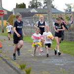 PHOTO BY RACHEAL ROSE 
Miller Junior High School runners race alongside A.J. West Elementary School competitors at a Hawaiian-themed Fun Run on Friday, May 8 in Aberdeen.