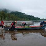 Amiran White / High Country News
During low tide on the Columbia River, Chinook tribal members push a traditional style canoe called Skakwal (which means Lamprey Eel in Chinuk wawa) toward the sea during the annual First Salmon Ceremony.