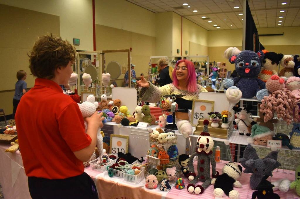 A vendor helps a customer during Summerween. (Jerry Knaak / The Daily World)