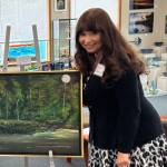 Jerry Knaak / The Daily World
Delores Lundgaard poses for a photo with one of her pieces at the Gallery of Ocean Shores.