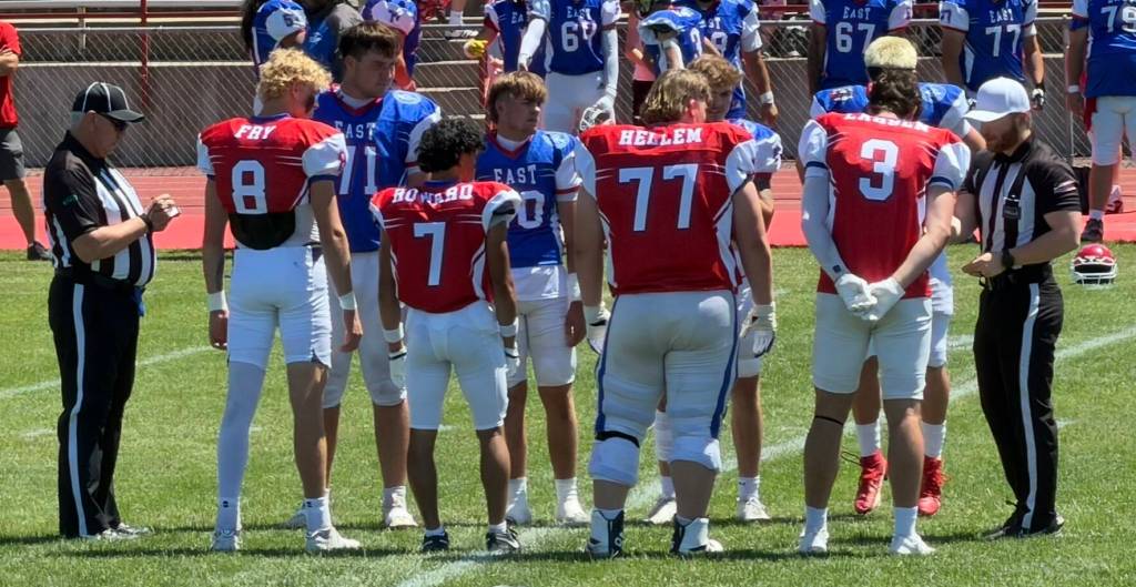 T. Michaels / The Daily World
East meets West: Captains in the all star football classic meet at midfield for the coin toss. Montesanos Mason Fry (#8) is on the left.