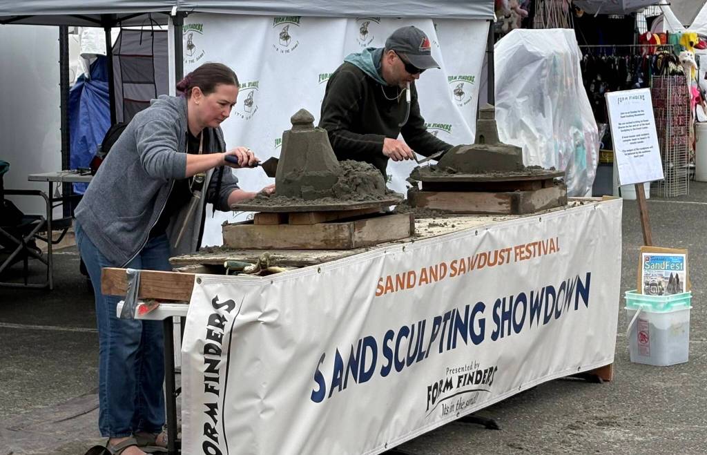 Jerry Knaak / The Daily World 
Two contestants compete in the sand sculpting showdown.