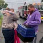 Michael Wagar / The Daily World
Family members are distraught, thinking their puppy was trapped inside a burning home. The crates hold two cats that were rescued.
