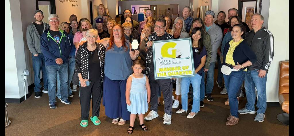 Rick Moyer and Greater Grays Harbor Ambassador Kiona Goodman hold the Member of the Quarter award at their reception at The Music Project. To Moyers right is Viola Gonzalez, his wife Amy and her sister Laura Rohr.