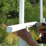 Andrea Watts / The Daily World
A volunteer secures a crossbeam to the post after its secured into the ground.