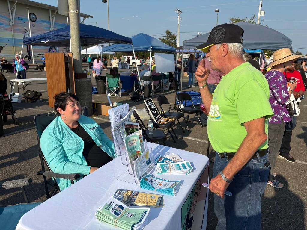 Michelle Traer (left) represented the Ocean Shores Public Library at National Night Out. (Jerry Knaak / The Daily World)